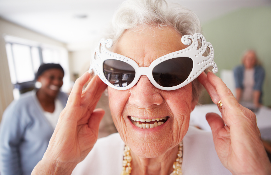 an elderly white woman with white hair wearing funky white sunglasses