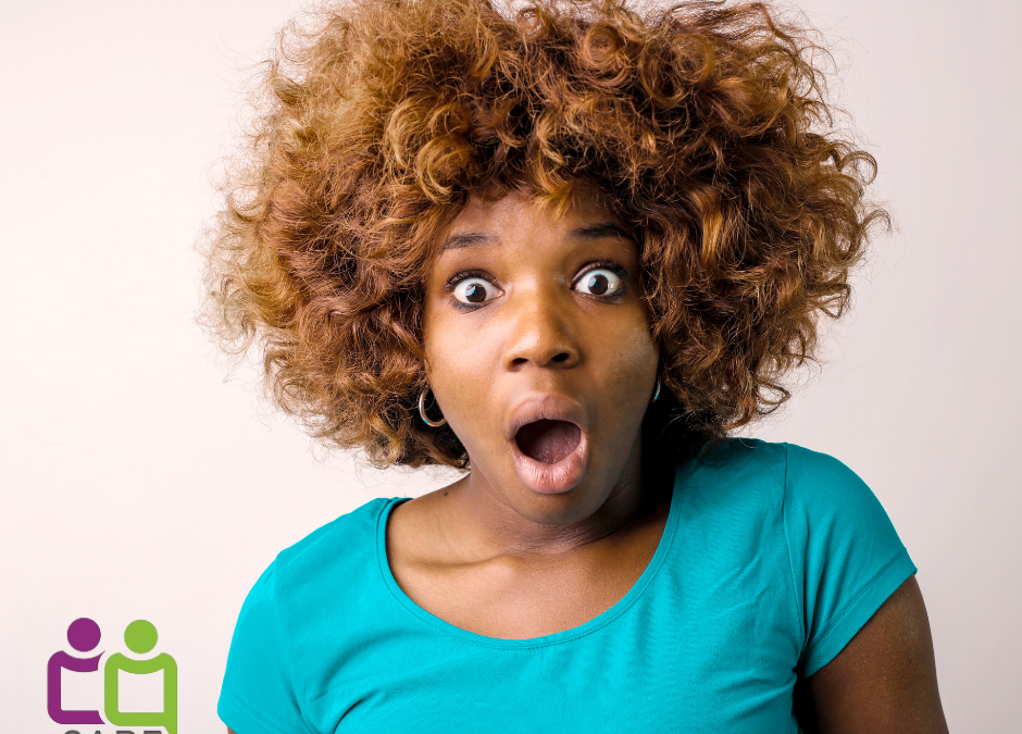 African American lady wearing a green t-shirt with an unhappy, surprised facial expression